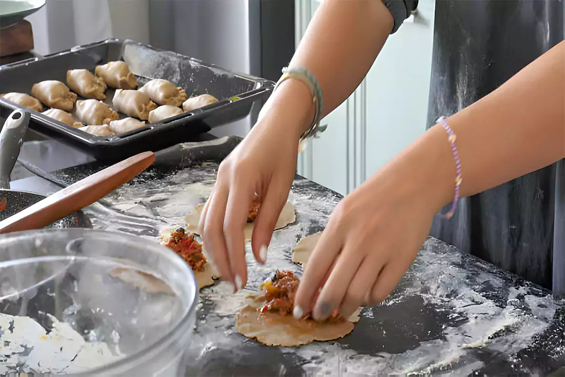 Preparing crescent roll taco bake with layers of crescent dough and taco filling.