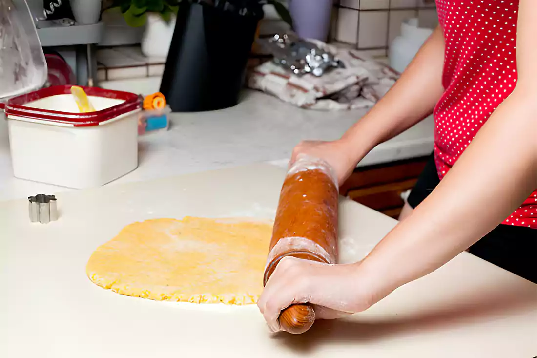 Baker kneading panettone dough on kitchen counter