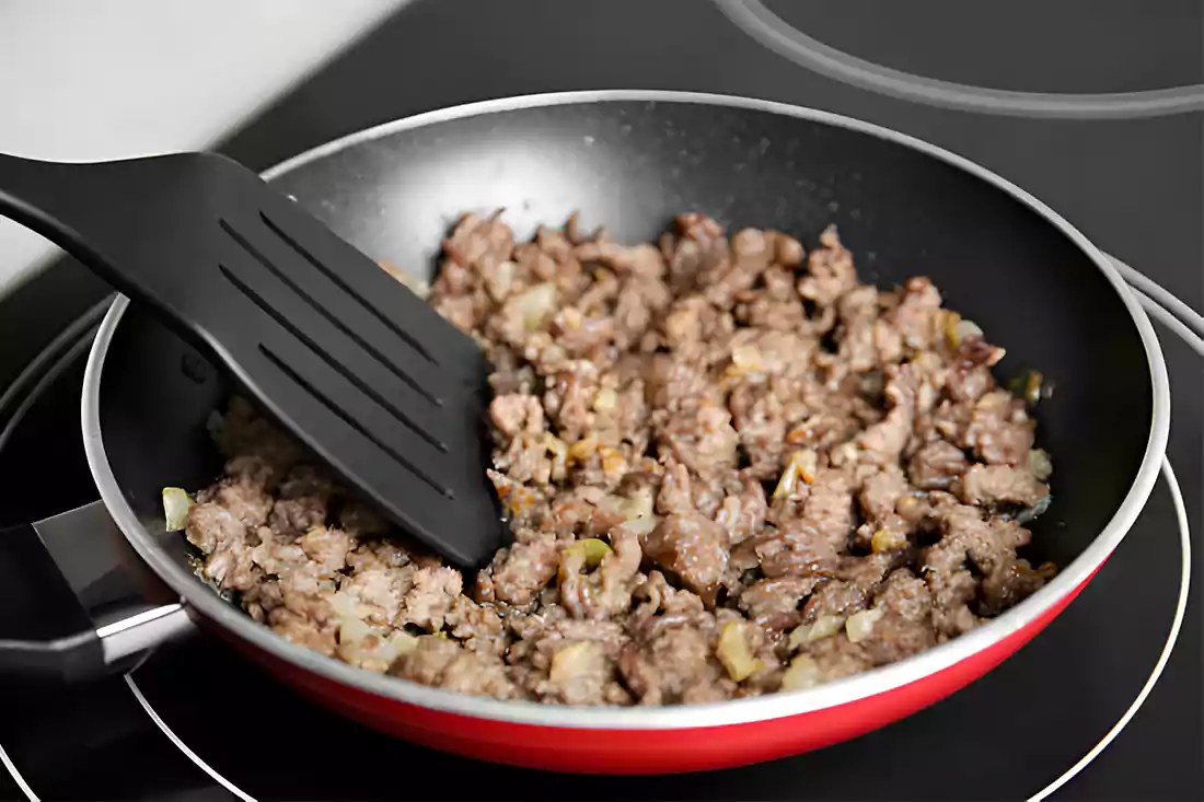 Ground beef being browned in a skillet, a key step in preparing Sloppy Joe Casserole.