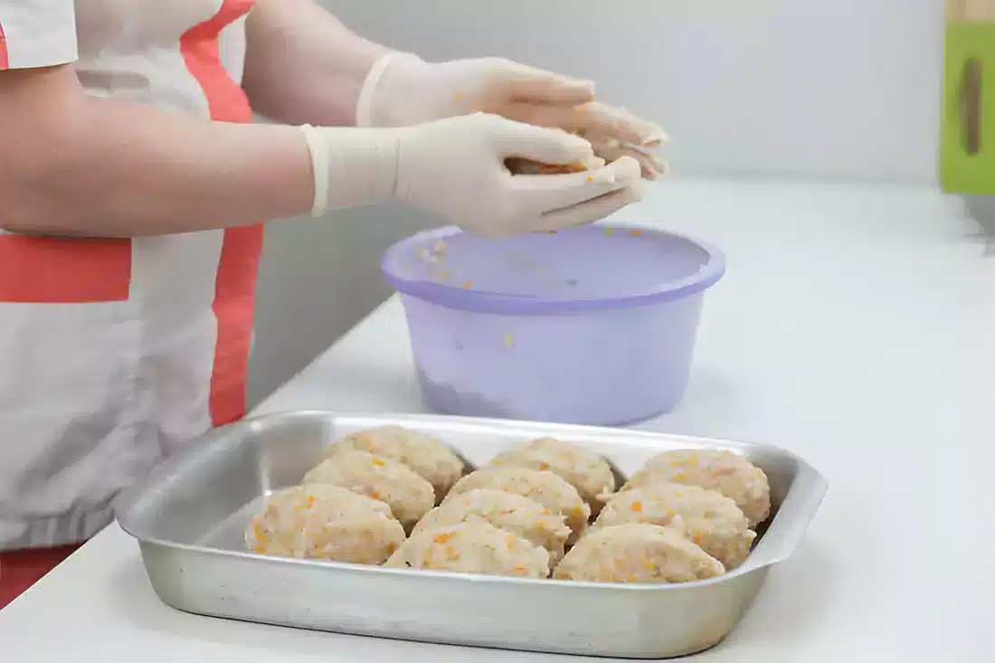 Hands delicately shaping crab cake mixture into patties