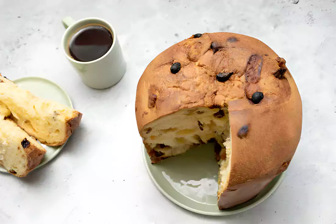 Sliced panettone on a serving plate with holiday decorations