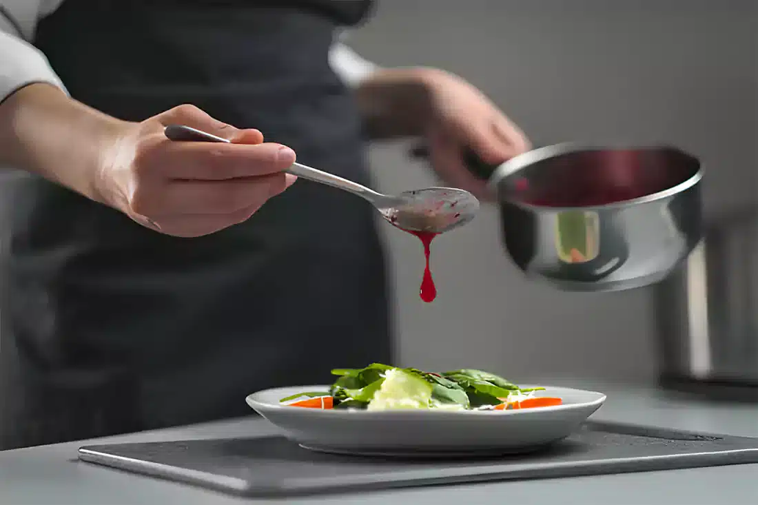 Chef preparing Chinese Chicken Salad with fresh ingredients in the kitchen